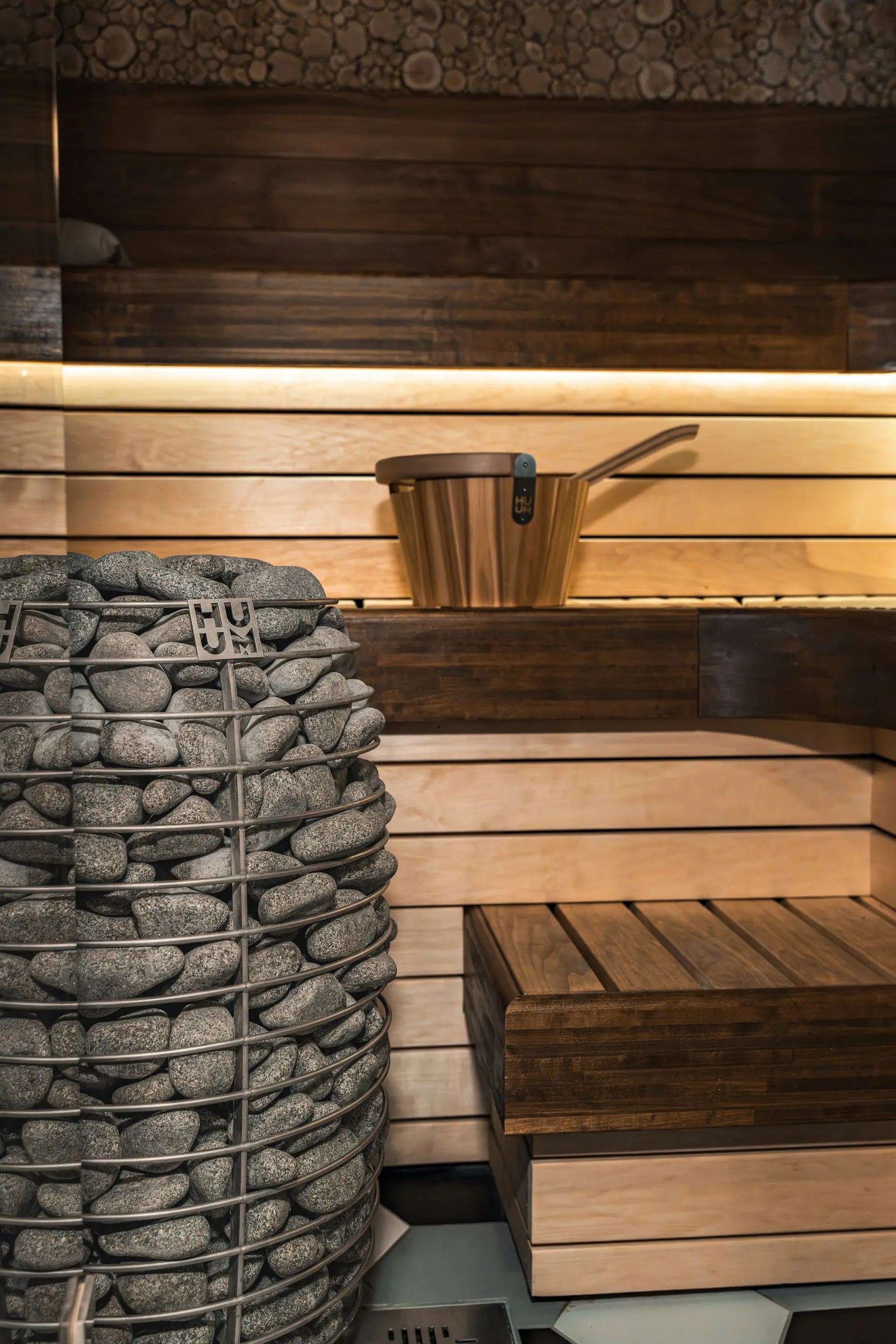 Wooden sauna with benches, a stone heater and a water bucket