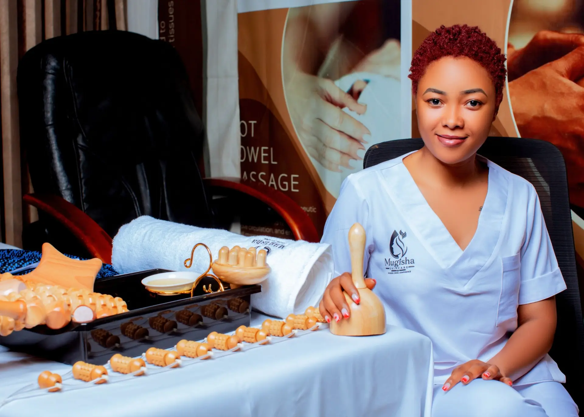 Therapist seated beside a table of wood therapy tools and rolled towels